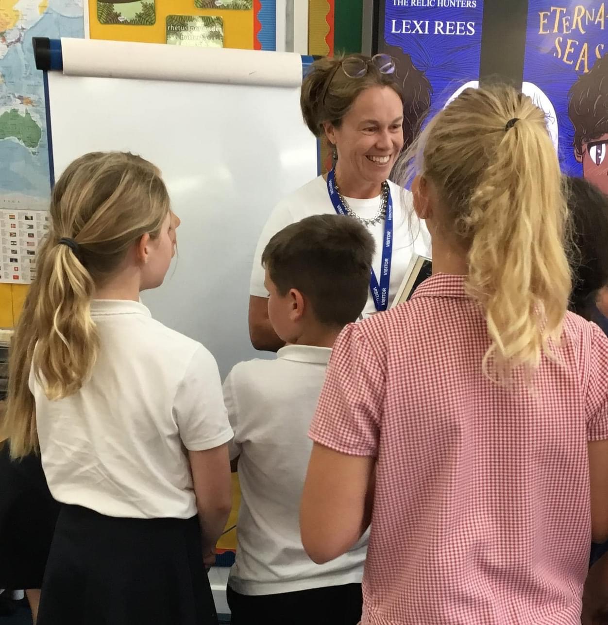 Lexi Rees with a queue of pupils asking for autographs following an author visit